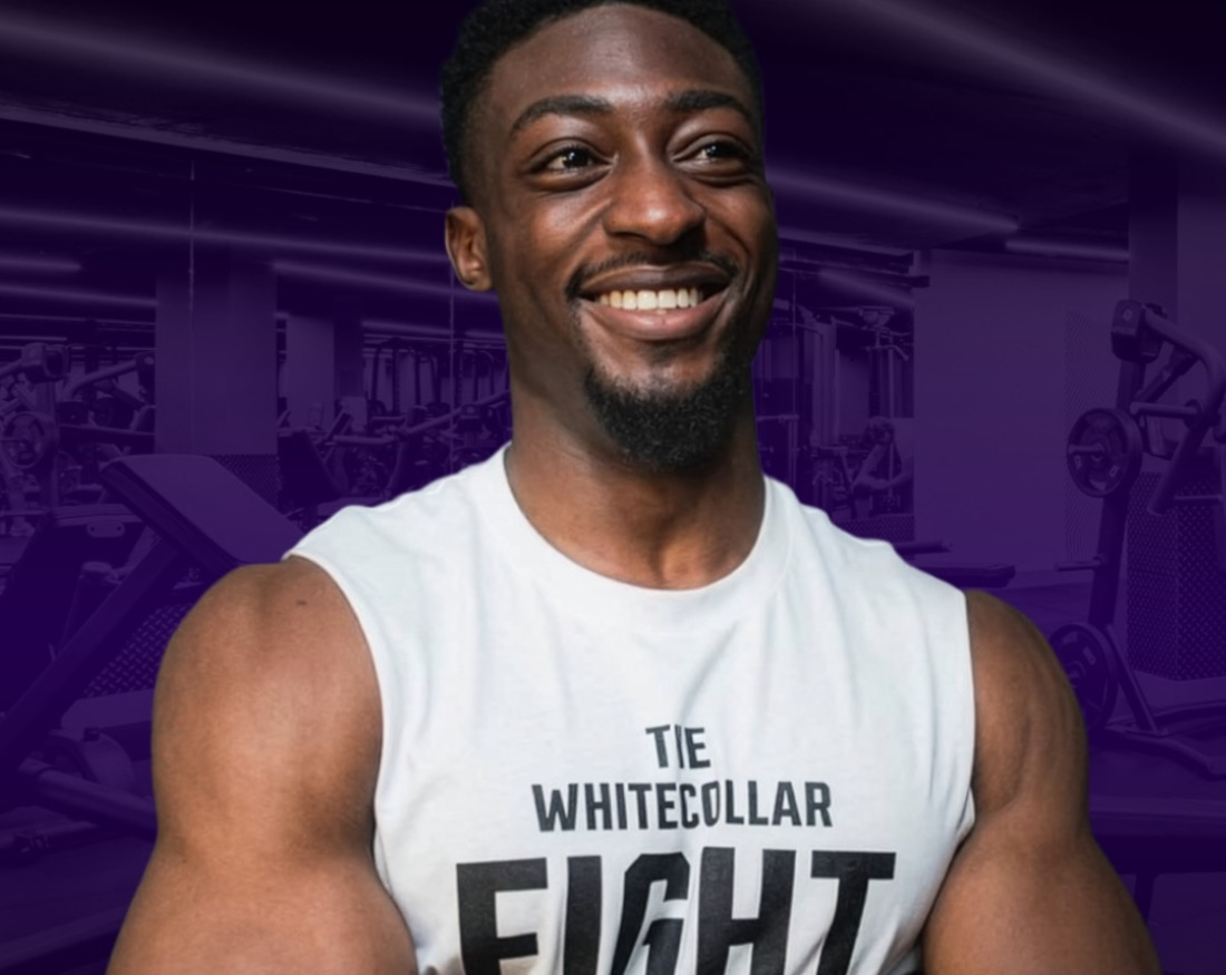 Olamide Doherty of Ola.DFit smiling in a gym, arms folded, wearing a Whitecollar Fight training vest